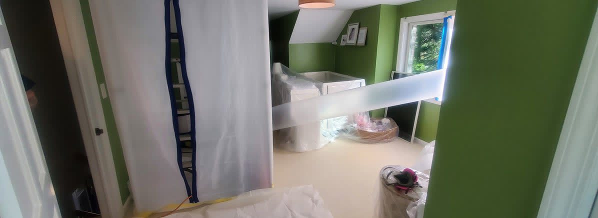 Mold remediation technician inspecting visible growth inside a protected work area